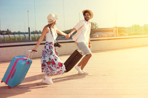 Happy young couple landed at the airport, arrived at the destination of vacation
